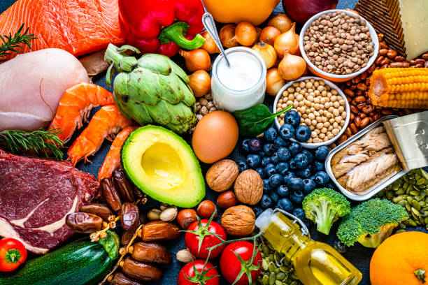 Colorful assortment of fresh and healthy food items including fruits vegetables meat fish dairy nuts and grains