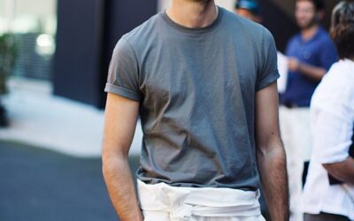 Casual street style look featuring a man in a grey t-shirt and white high-waisted pants tied with a fabric belt.