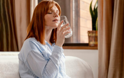 Importance of Water for Brain Functioning A calm woman drinking a glass of water at home to stay hydrated and mentally refreshed