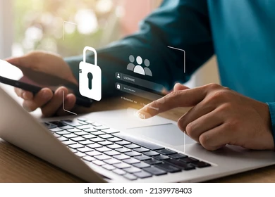 Person securing login credentials on laptop with smartphone — concept of online data protection and cybersecurity.