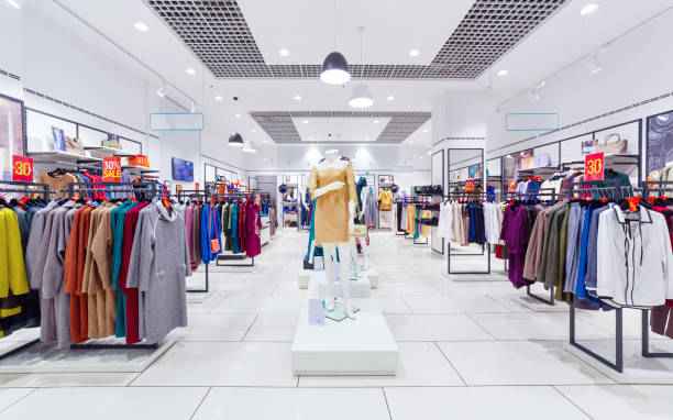 Interior view of a modern clothing store with mannequins and organized racks of colorful clothes.