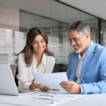 Businessman and businesswoman discussing documents in a modern office setting