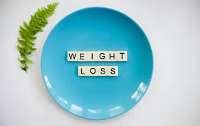 5 Morning Habits That Can Speed Up Your Weight Loss Journey Blue plate with the words "Weight Loss" spelled in scrabble tiles and a green leaf on the side