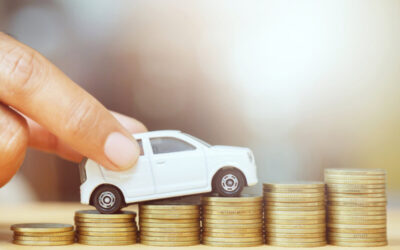 Tips to Increase Your Car’s Resale Value Hand pushing toy car up stacked coins symbolizing car finance or saving for vehicle