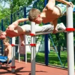 Workout outdoor calisthenics training with young men performing strength exercises on parallel bars