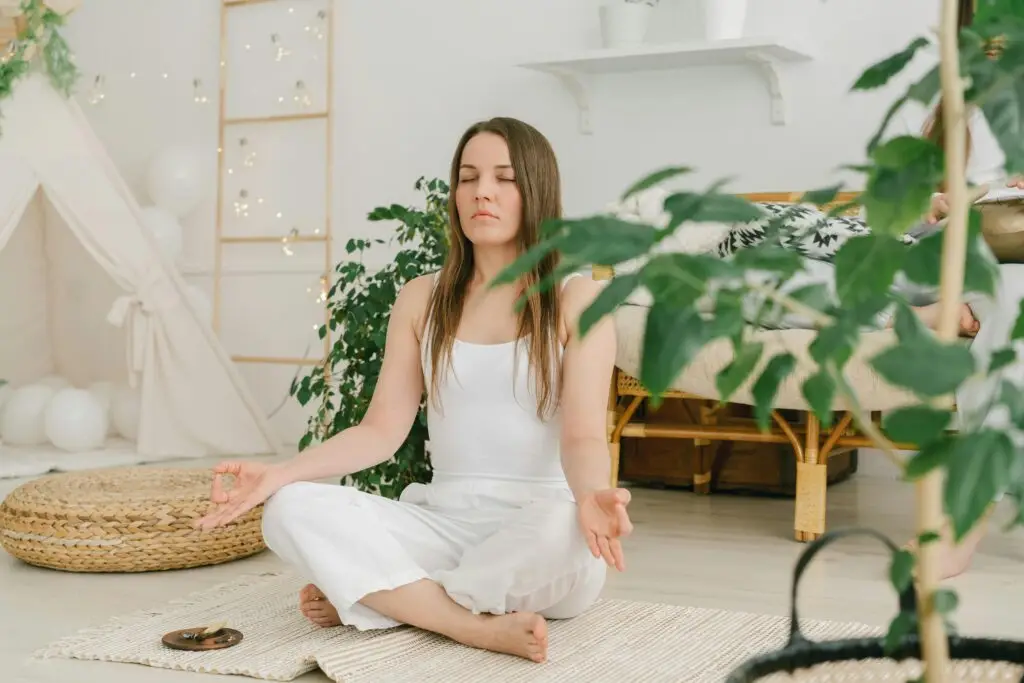 Woman practicing meditation indoors to support healthy living, stress relief, and emotional balance